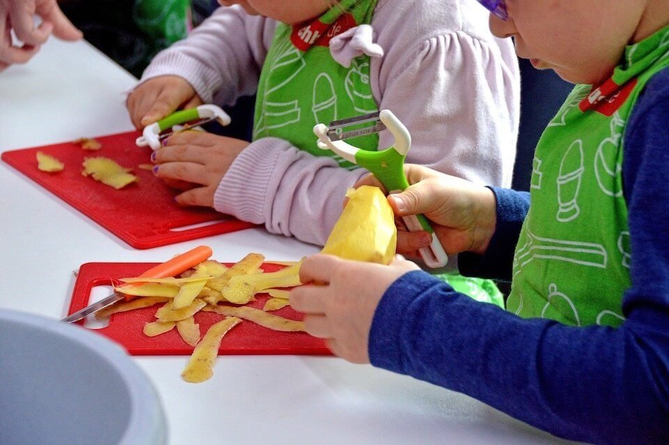 Kinder schneiden gemeinsam Obst – Körper, Bewegung und Gesundheit